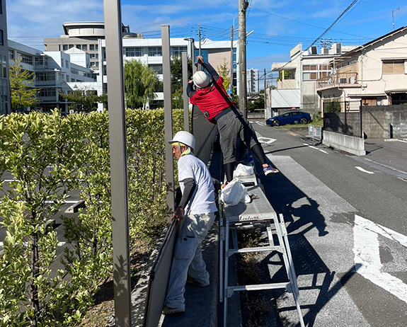 作業員2名がフェンスの解体作業を行なっている場面