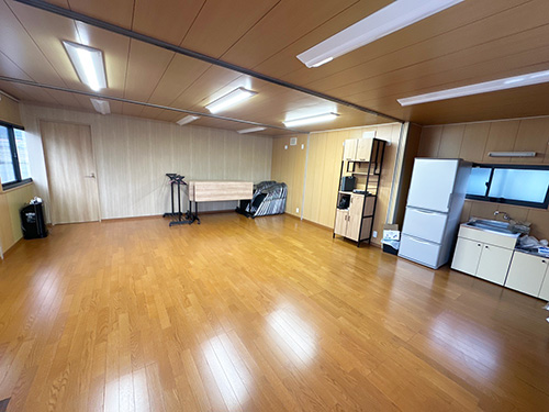 第三駐車場にある事務所及び寮の部屋の写真 キッチンと冷蔵庫等がある少し広い部屋
